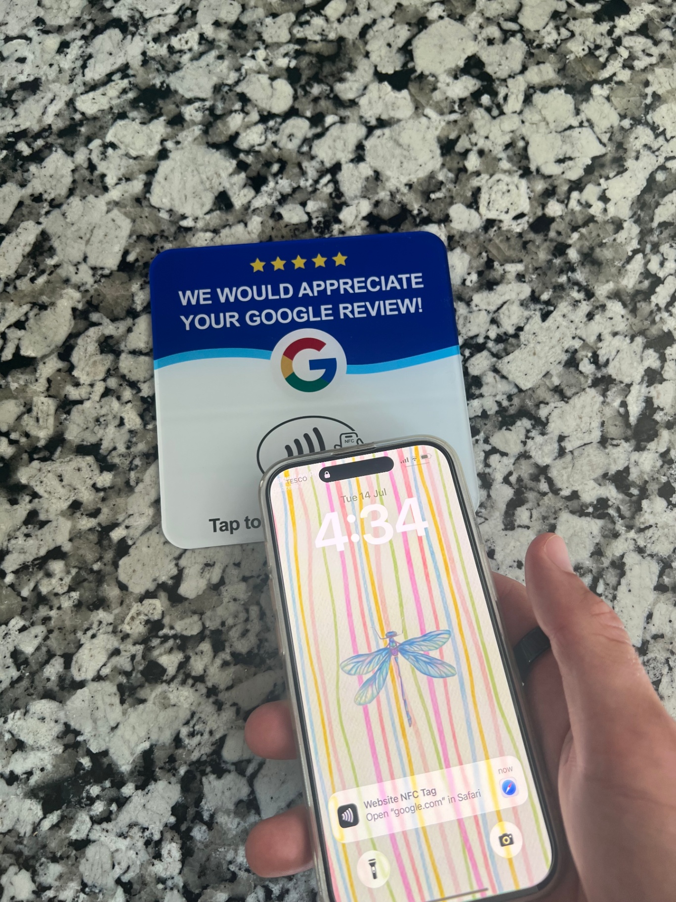 Customer tapping a smartphone against an NFC review stand